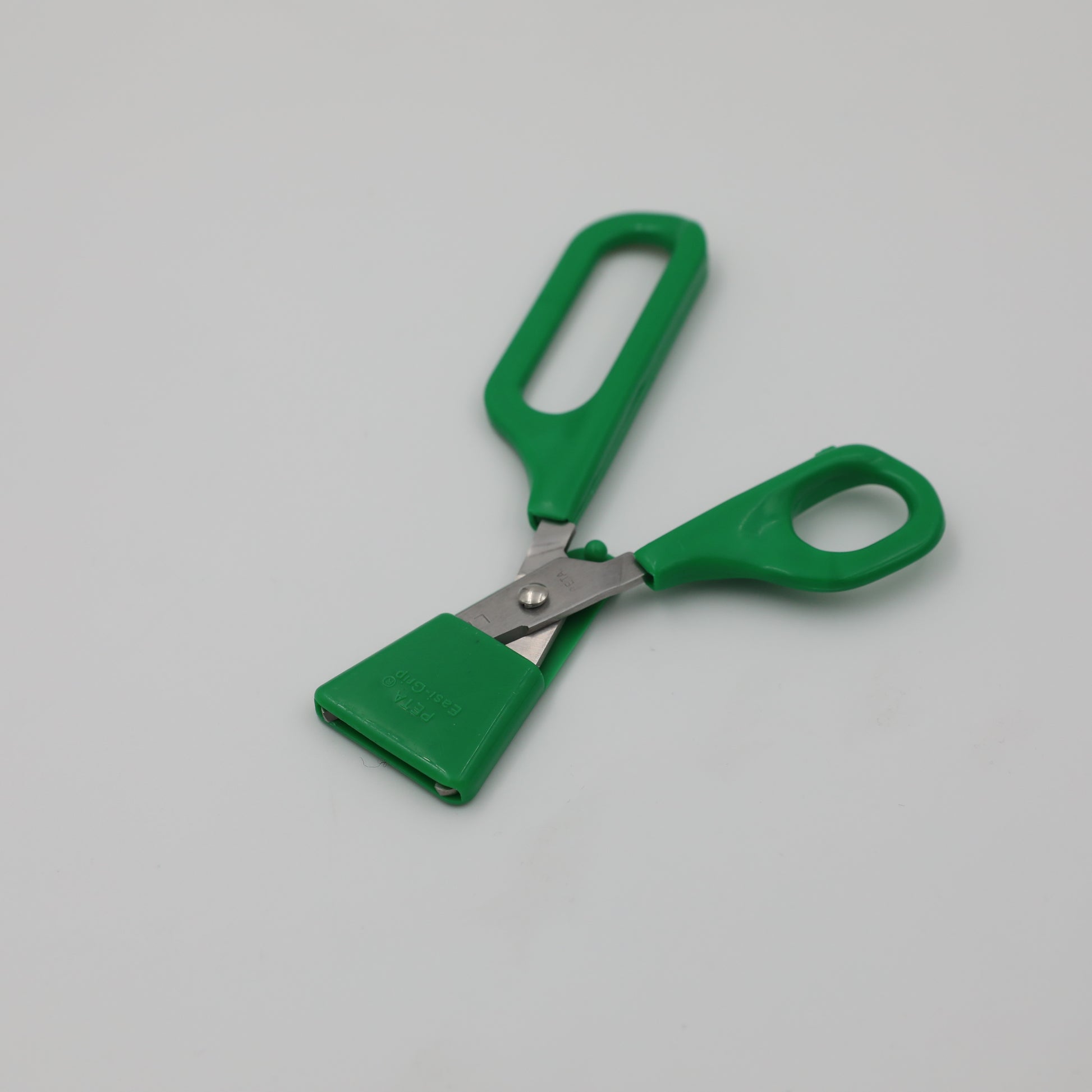 Left-handed Long Loop Self-Opening Scissors with green handle and protective green blade guard on for safe storage.