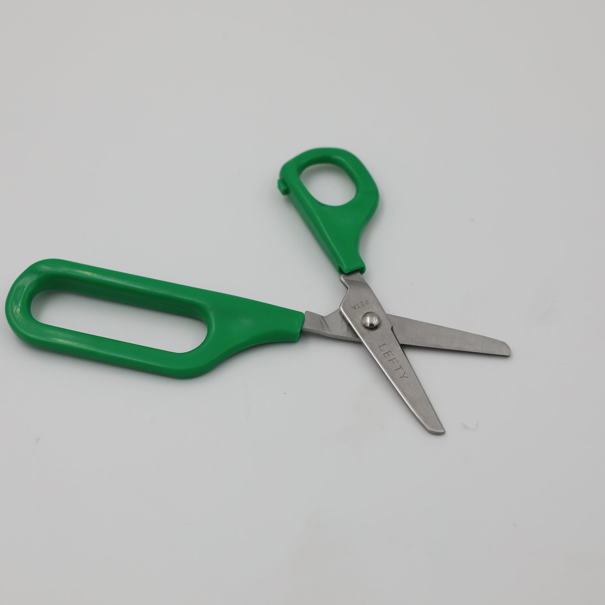 Left-handed Long Loop Self-Opening Scissors with green handle, featuring a discreet spring for easier cutting.