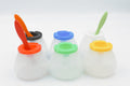 Set of 6 Extra Wide Non-Spill Paint Pots in black, white, green, blue, yellow, and red with two paintbrushes in the green and yellow pots, showing versatile use. Paint brushes not included.