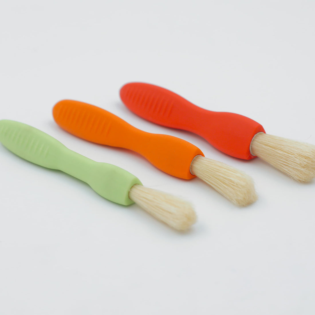 Set of 3 Triangle Easy Grip Paint Brushes in red, green, and orange, with ergonomic, non-roll handles.