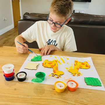 Child painting a Safari craft kit at home, hands-on learning with KJ's Craft Time