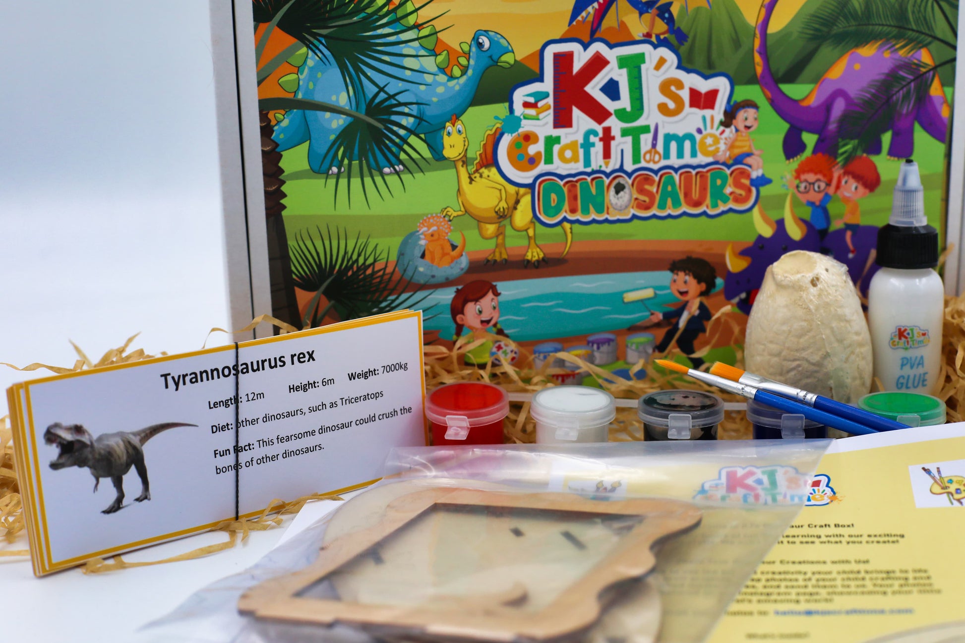 Close-up of dinosaur craft kit materials including educational dinosaur flashcards, paint pots and craft supplies